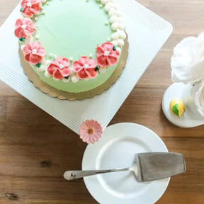 Nora Fleming Stoneware Square Pedestal with a cake on a table