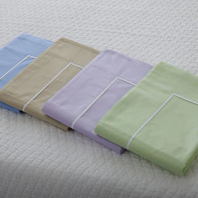 Gracious Home Bali Duvet Cover in various colors stacked together on a bed
