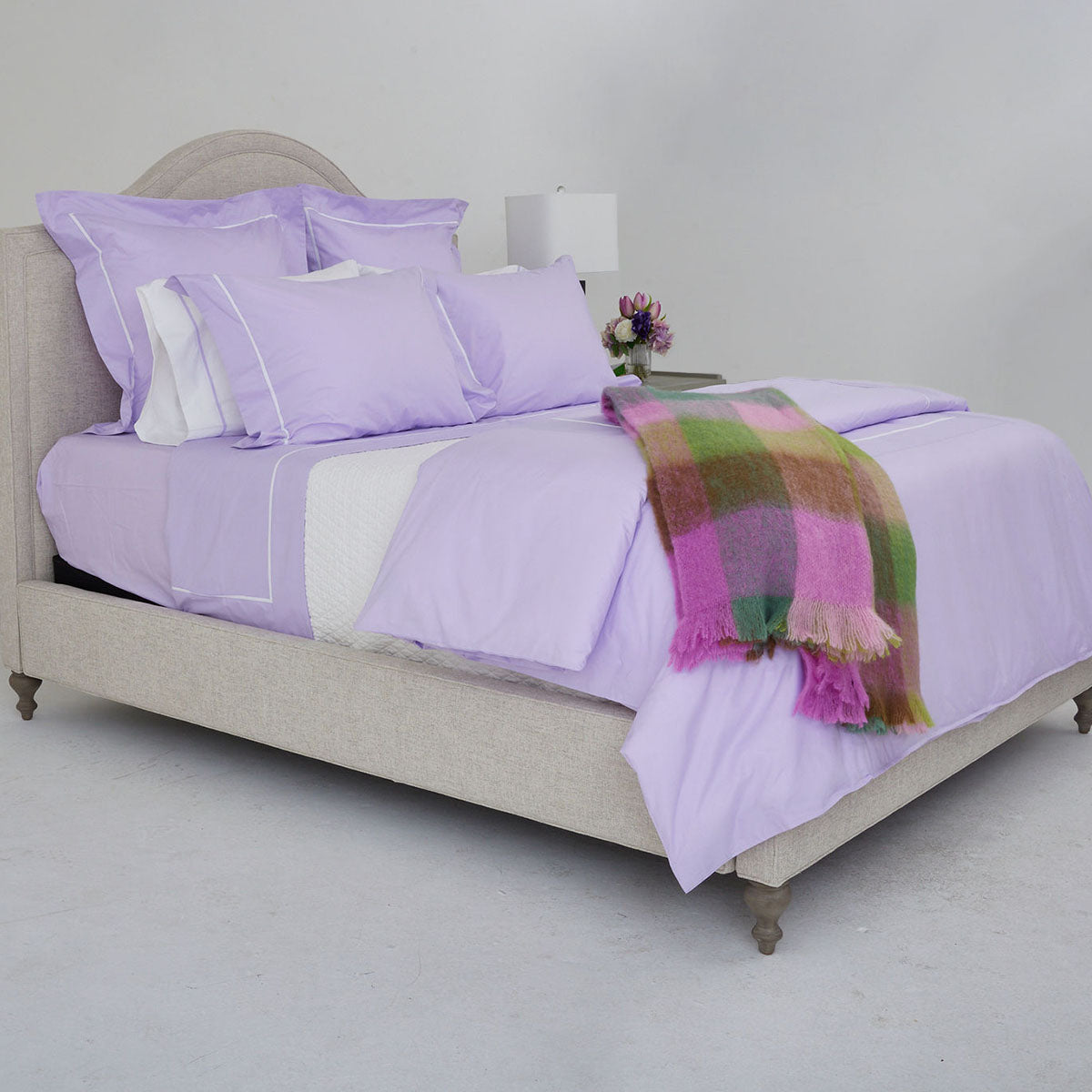 Image of a bed made with the Gracious Home collection bedding set in a light purple
