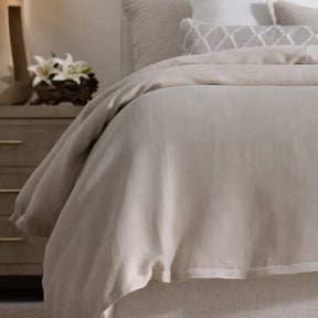 Lili Alessandra Rain Duvet Cover in Natural Cotton and Linen draped on a bed in a room