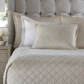 Lili Alessandra Chloe Diamond Quilted Coverlet in Ivory Velvet draped on a bed in a room
