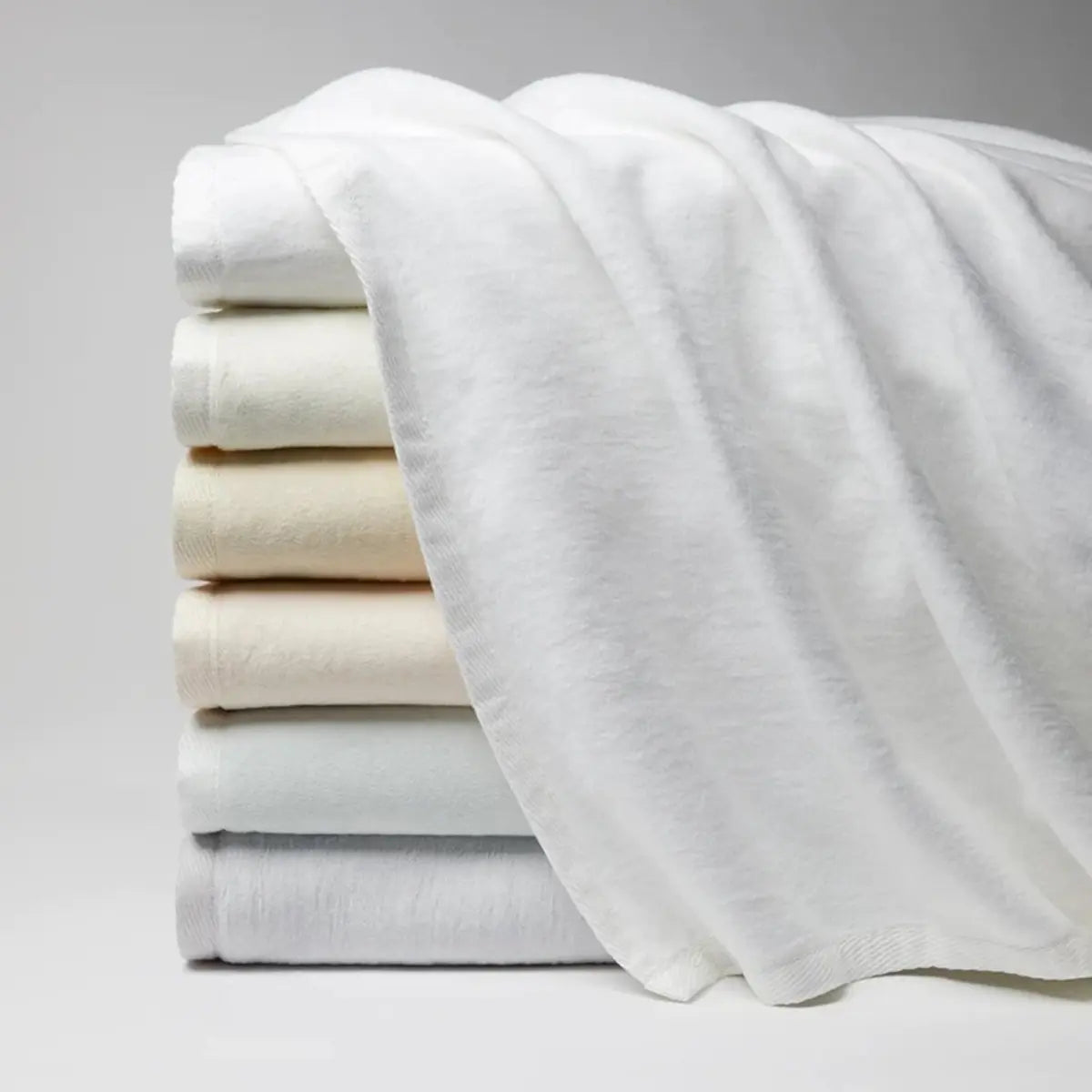 Sferra St Moritz Blankets stacked together in various colors 