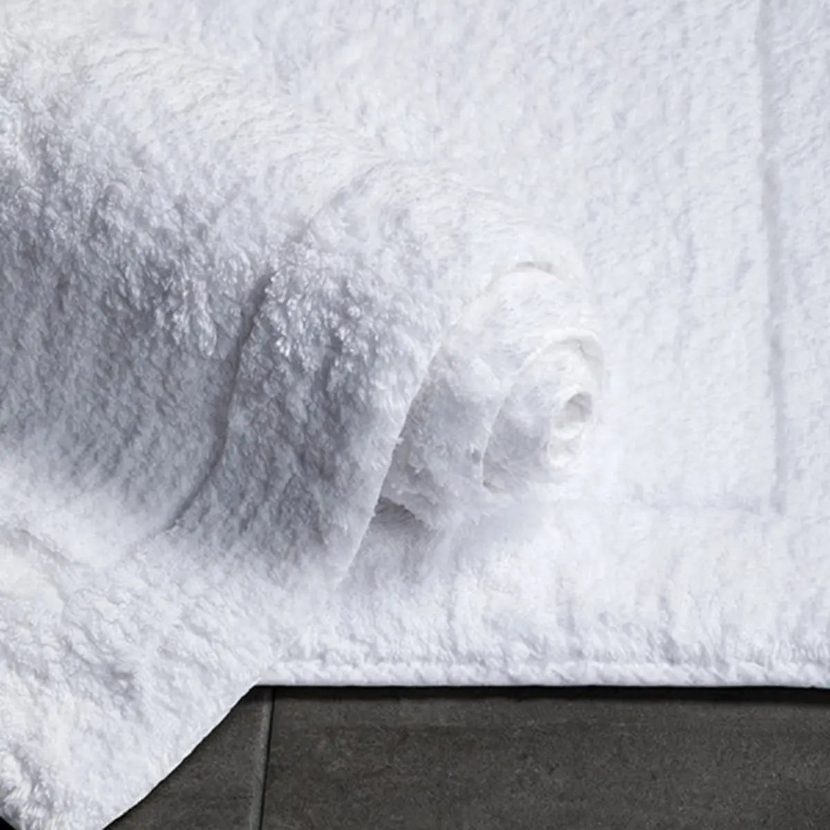 Sferra Maestro Bath Rug in White and rolled up