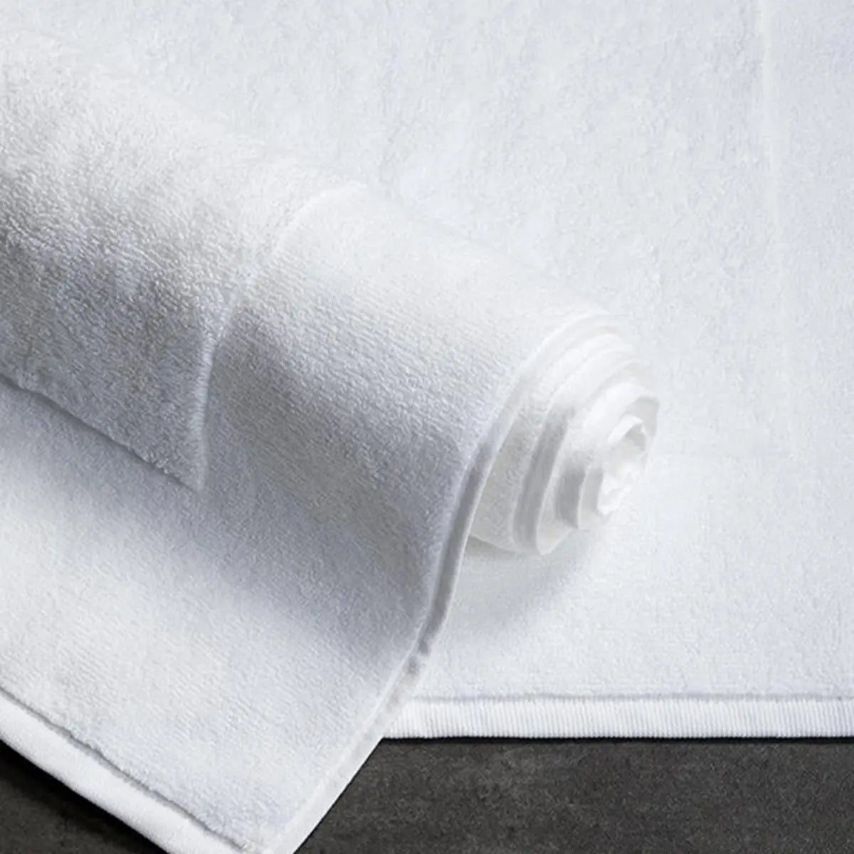 Sferra Bello Tub Mat in White, rolled up on the floor