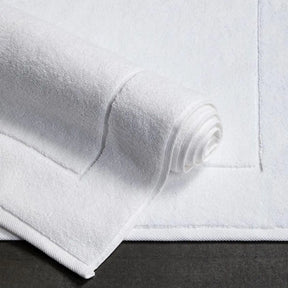 Sferra Sarma Tub Mat in White partially rolled on the floor