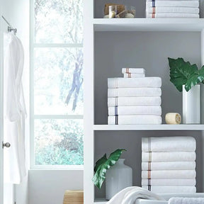 Sferra Aura Bath Towel Collection stacked on a bathroom shelf