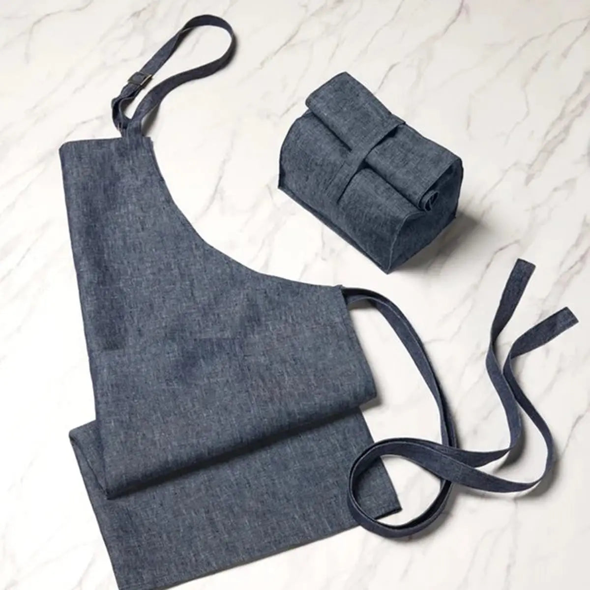 Sferra Cucina Apron in Denim folded and unfolded on the floor