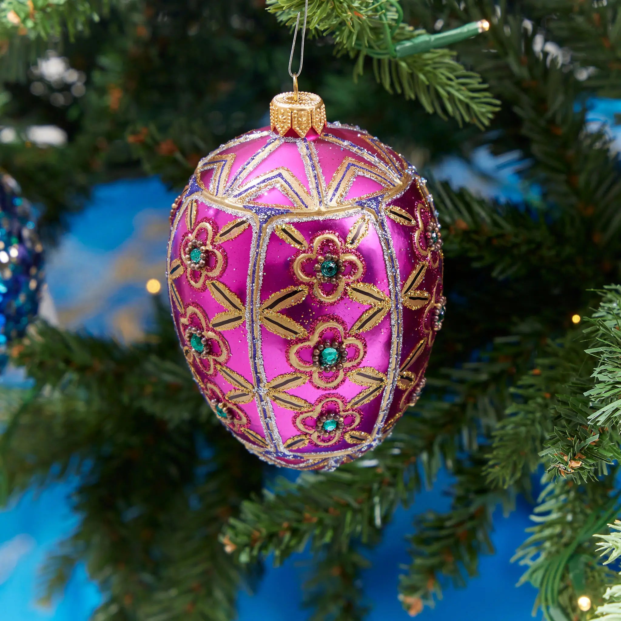 Winter Street Dark Pink Encrusted Large Egg Ornament hung on a tree