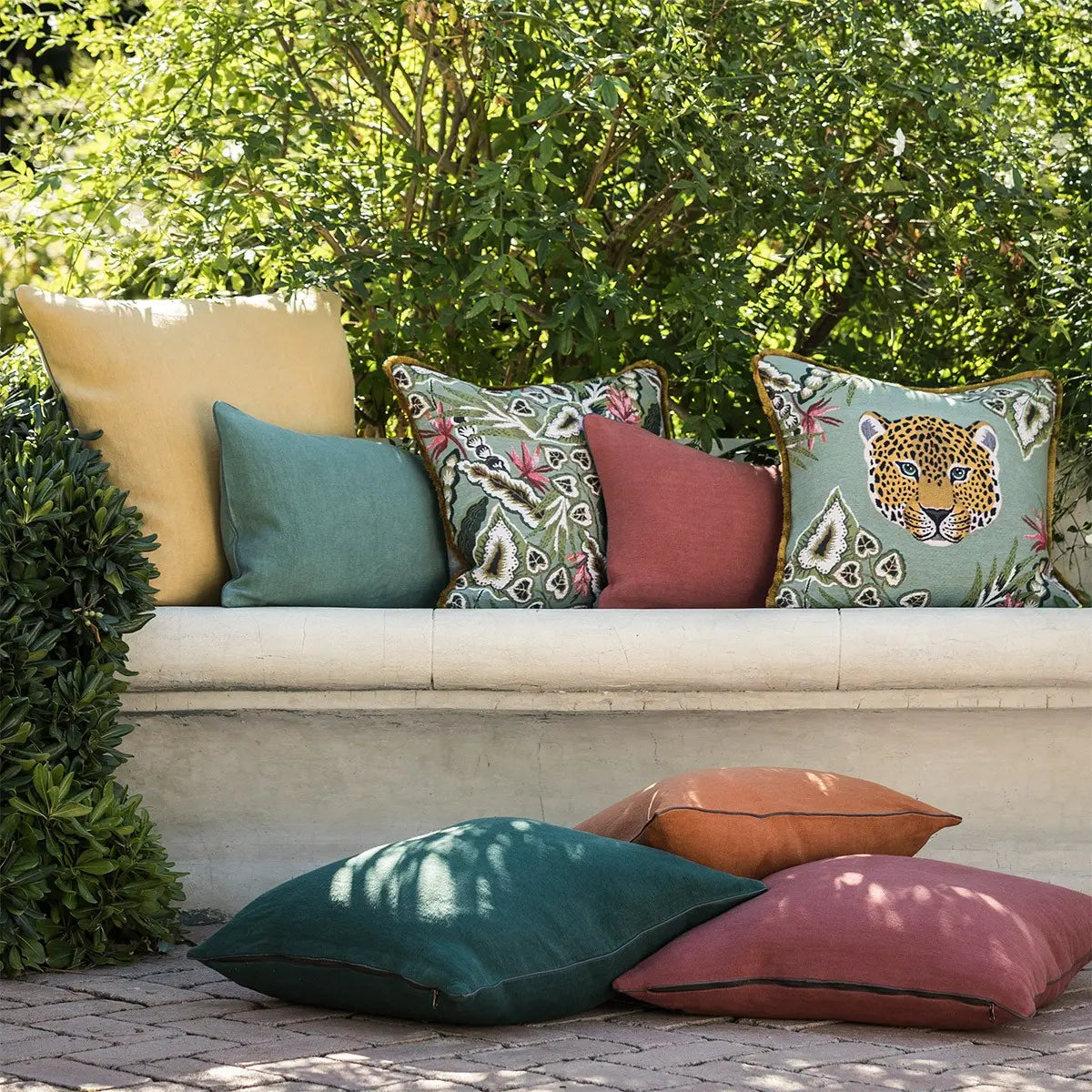 Yves Delorme Bergame Mousse Decorative Pillow 18 x 18 outdoors on a bench