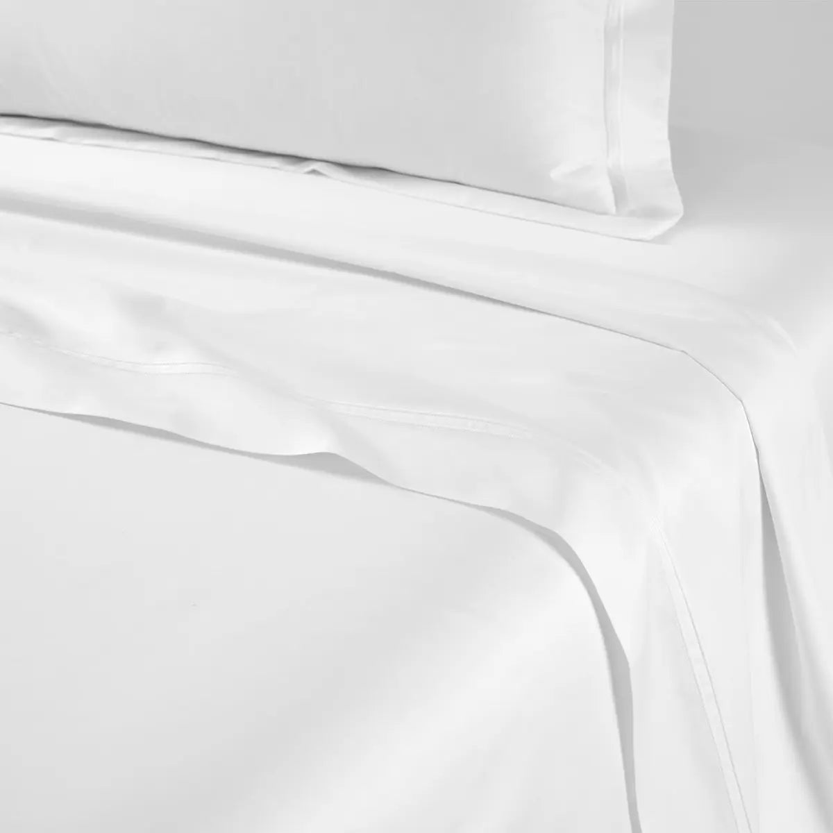 Yves Delorme Triomphe Flat Sheet in white on a bed