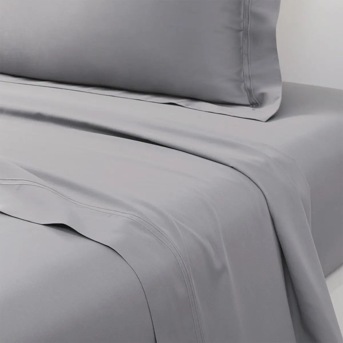 Yves Delorme Triomphe Flat Sheet in Platine on a bed