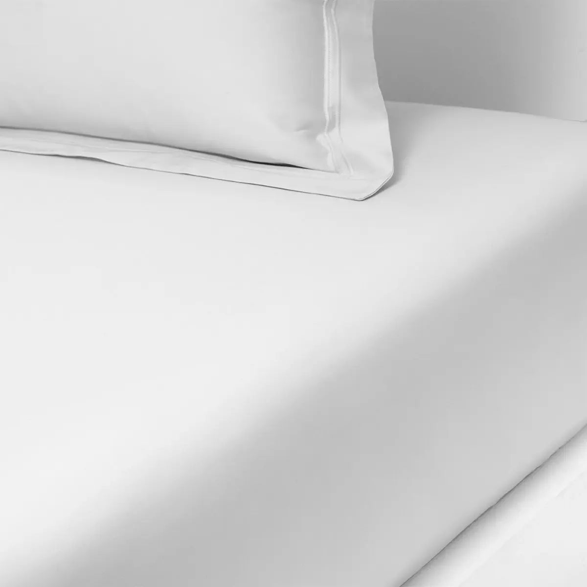 Yves Delorme Triomphe Fitted Sheet in Blanc on a bed
