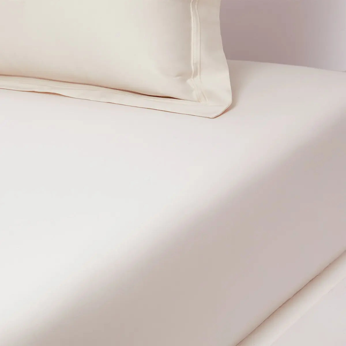 Yves Delorme Triomphe Fitted Sheet in Nacre on a bed
