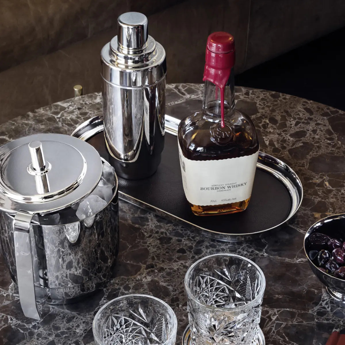 GEORG JENSEN MANHATTAN TRAY WITH A WHISKEY BOTTLE AND OTHER BARWARE ON A DINING ROOM TABLE