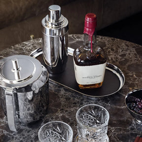 GEORG JENSEN MANHATTAN TRAY WITH A WHISKEY BOTTLE AND OTHER BARWARE ON A DINING ROOM TABLE