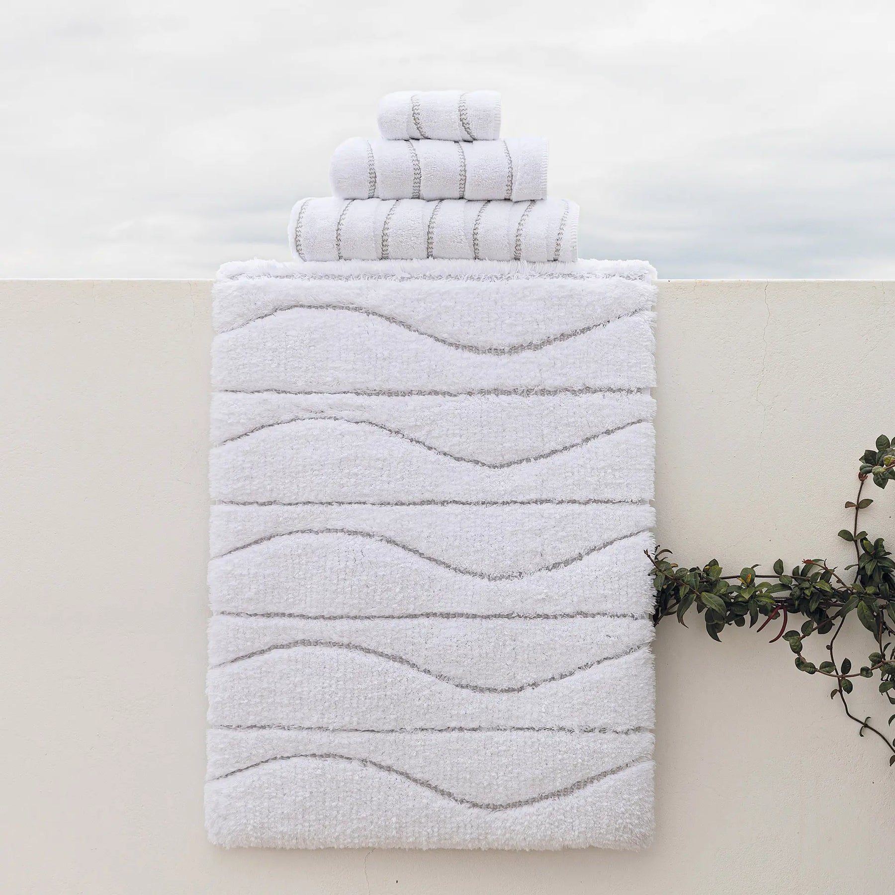 Graccioza Opera Bath Rug and Towels set outside on a ledge