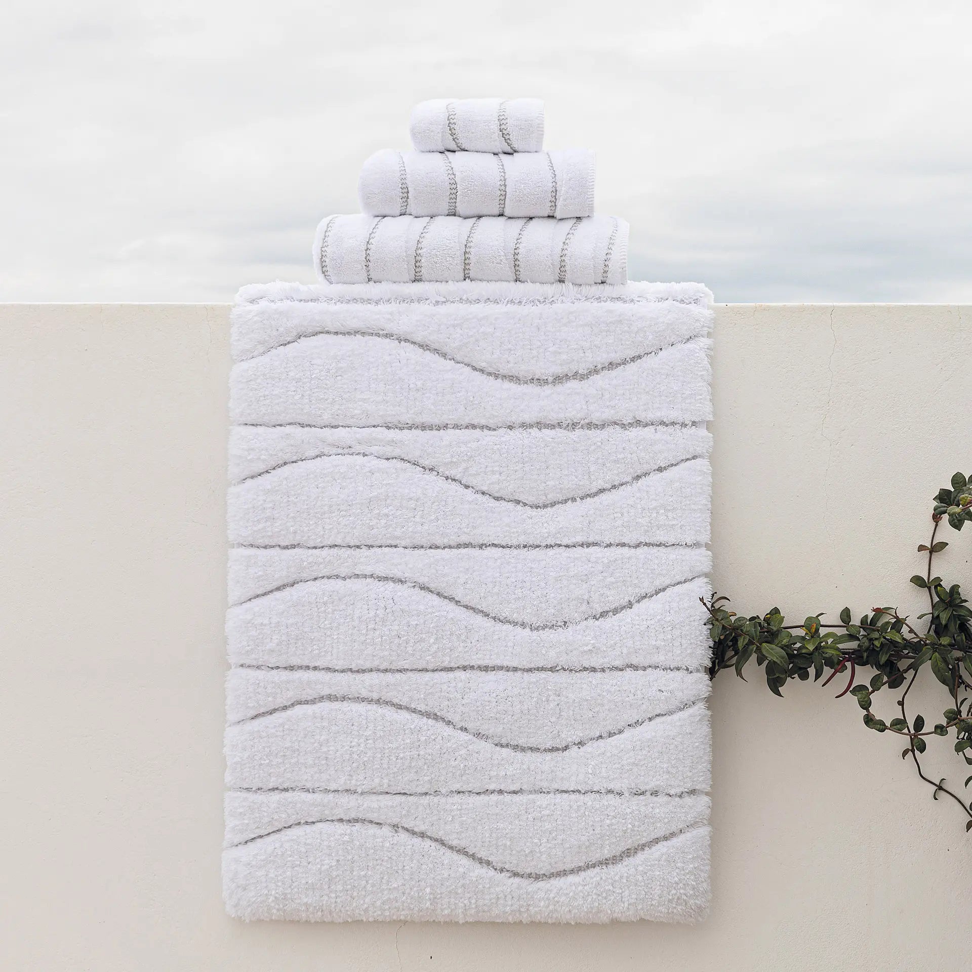Graccioza Opera Bath Rug and Towels set outside on a ledge