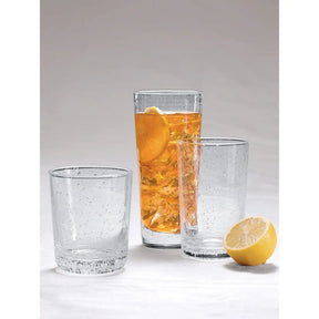 Mariposa Bellini Highball Glass next to a lemon and other glasses