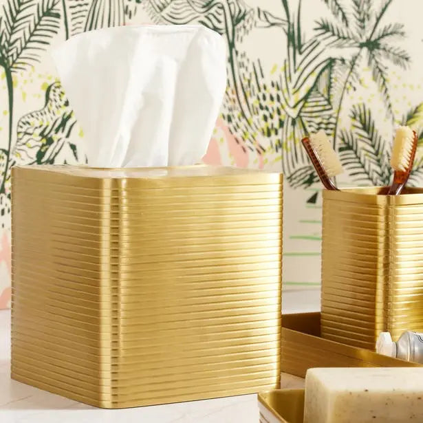 Pigeon & Poodle Adelaide Square Tissue Box Holder in Matte Gold Brass set in a room set next to other vanity items.