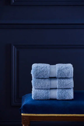 Three Stacked Yves Delorme Towel in Azure in a room